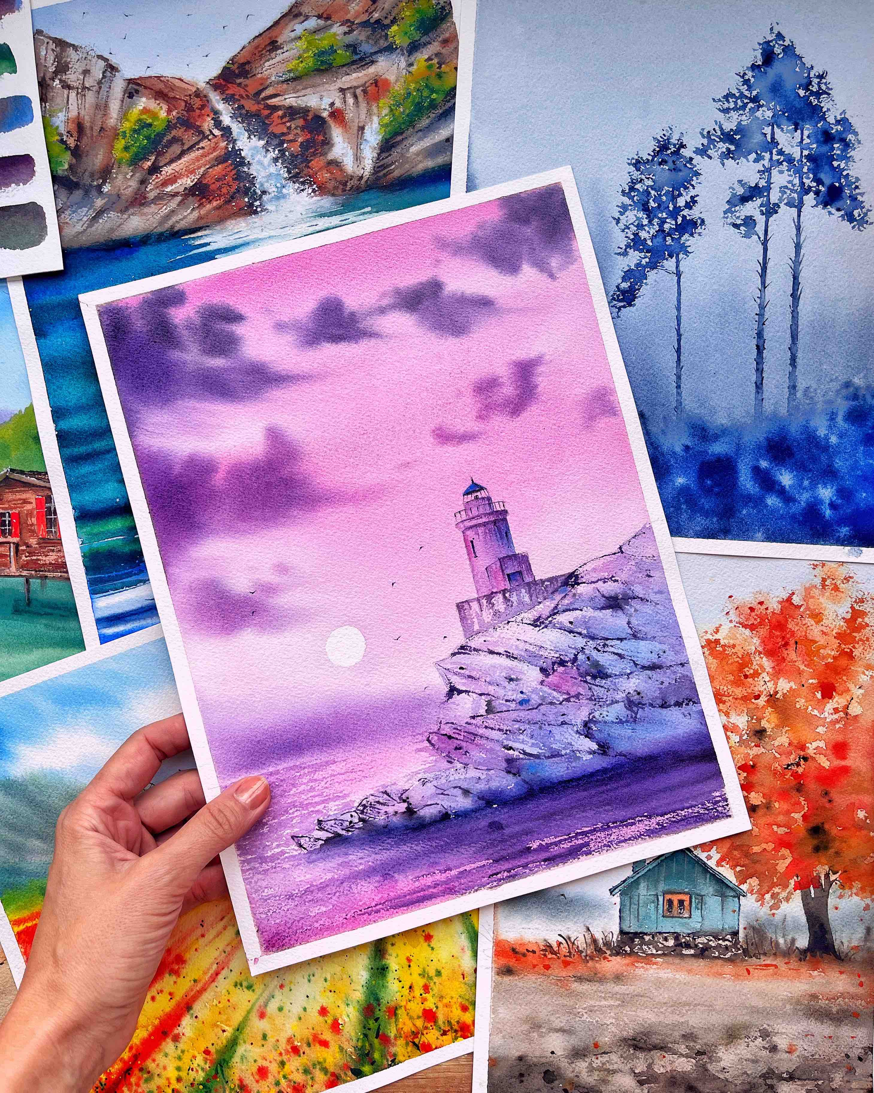A stack of vibrant watercolor paintings